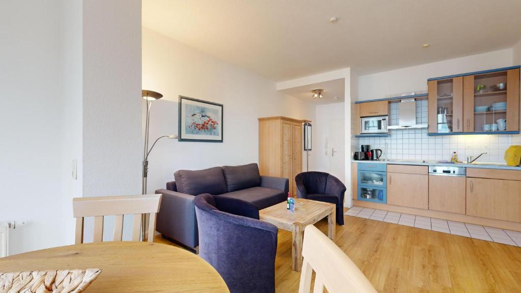 ein Wohnzimmer mit einem Sofa und einem Tisch sowie eine Küche in der Unterkunft Haus Saxonia in Binz