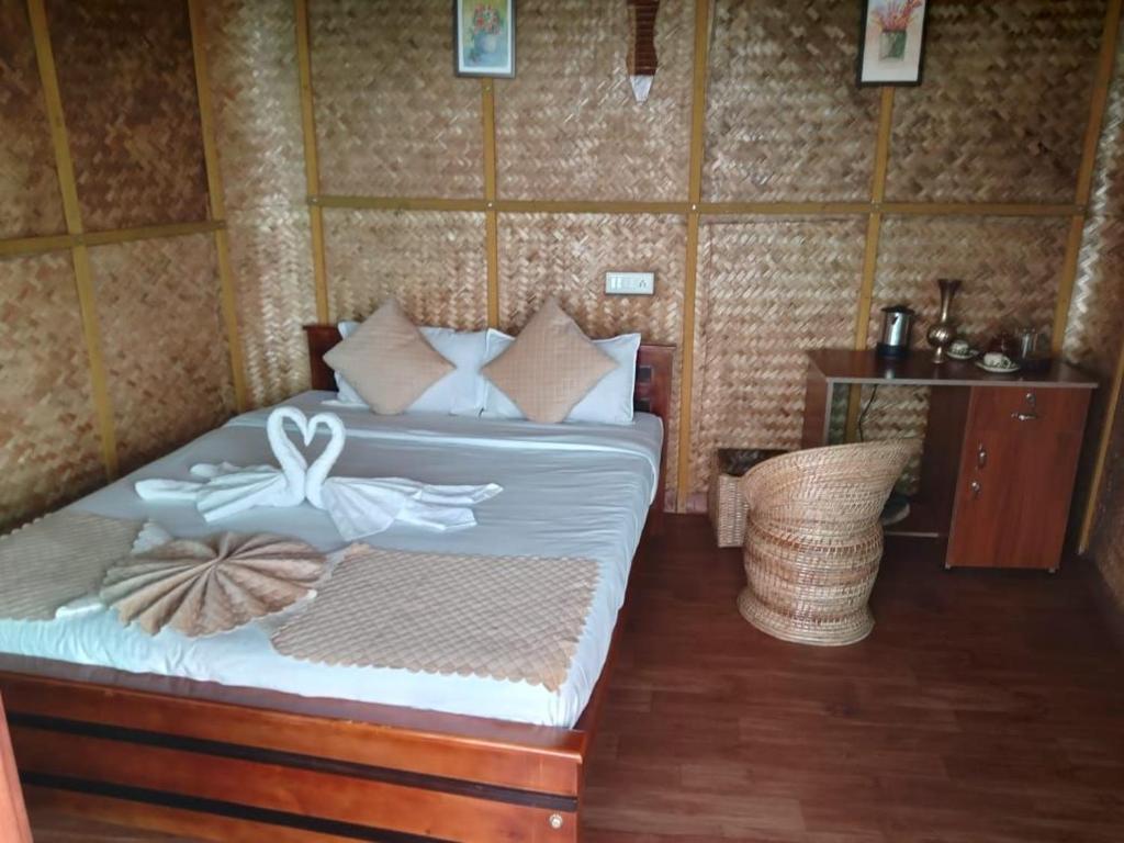 Schlafzimmer mit einem Bett mit weißer Bettwäsche und Kissen in der Unterkunft Qatsyir Horizon in Varagampadi