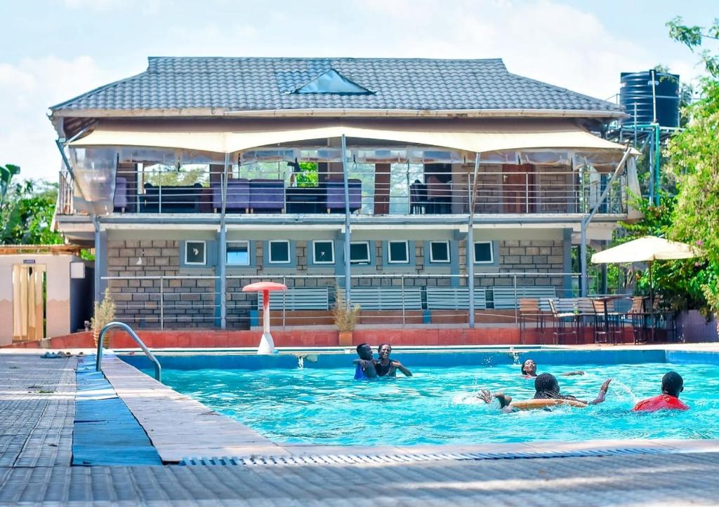 eine Gruppe von Personen, die in einem Schwimmbad schwimmen in der Unterkunft Galore Luxury Resort in Maseno