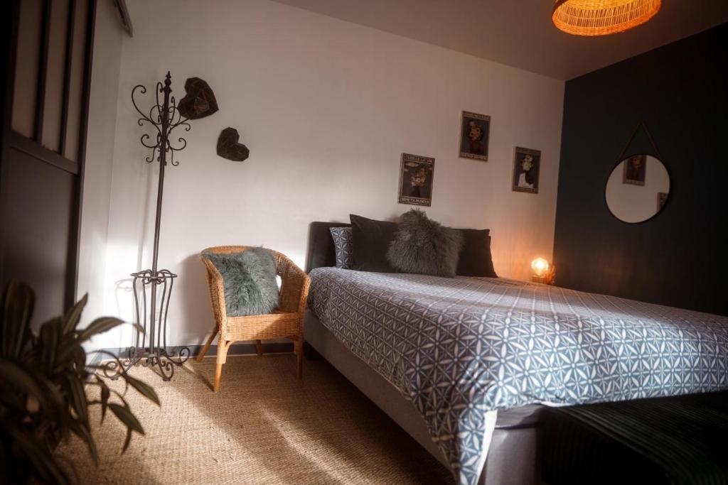 een slaapkamer met een bed en een stoel bij Chez Guilem in Saint-Maixent-lʼÉcole