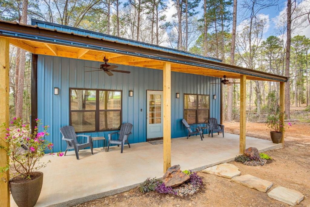 une maison bleue avec des chaises et une terrasse dans l'établissement Winnsboro Barndominium with Fire Pit and Large Deck!, à Winnsboro