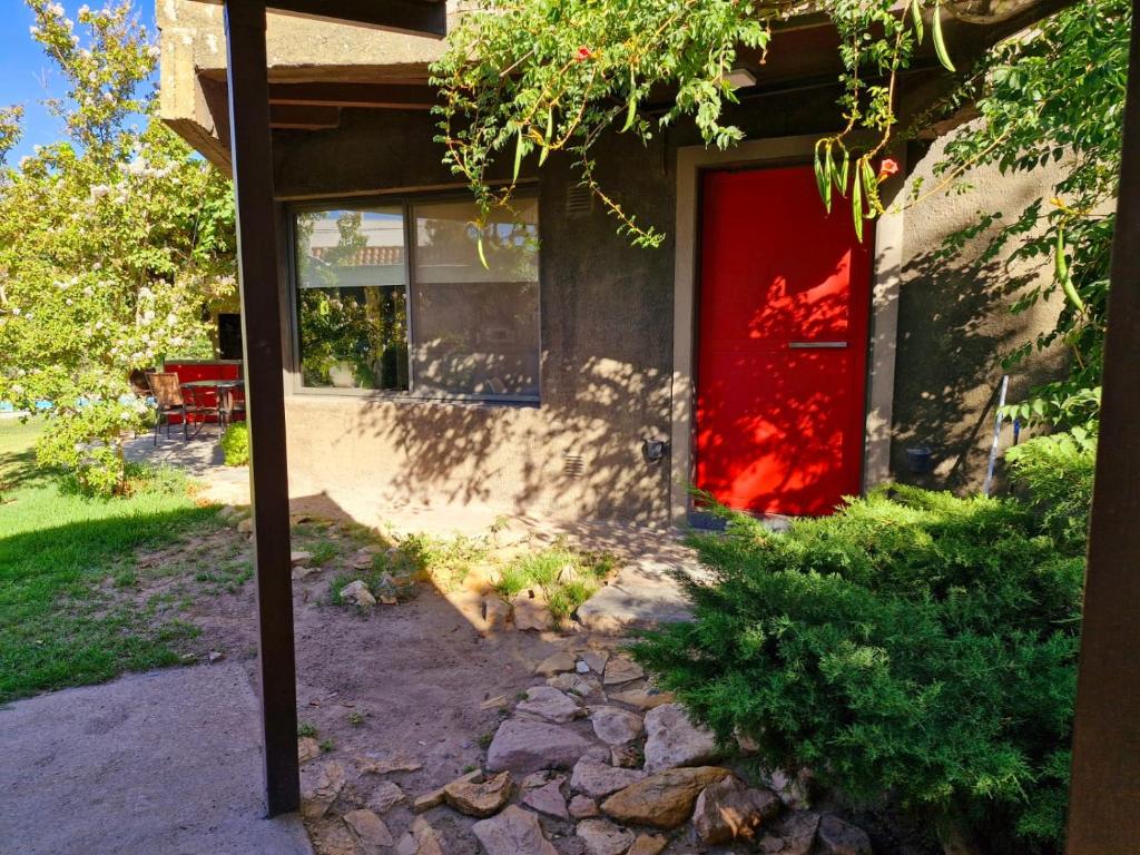 una puerta roja al lado de una casa en Casa Chacras de Coria en Mayor Drumond