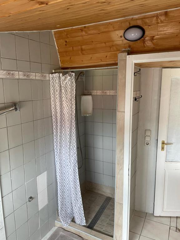 a bathroom with a shower with a shower curtain at Lenzl's Panzió in Szigetvár