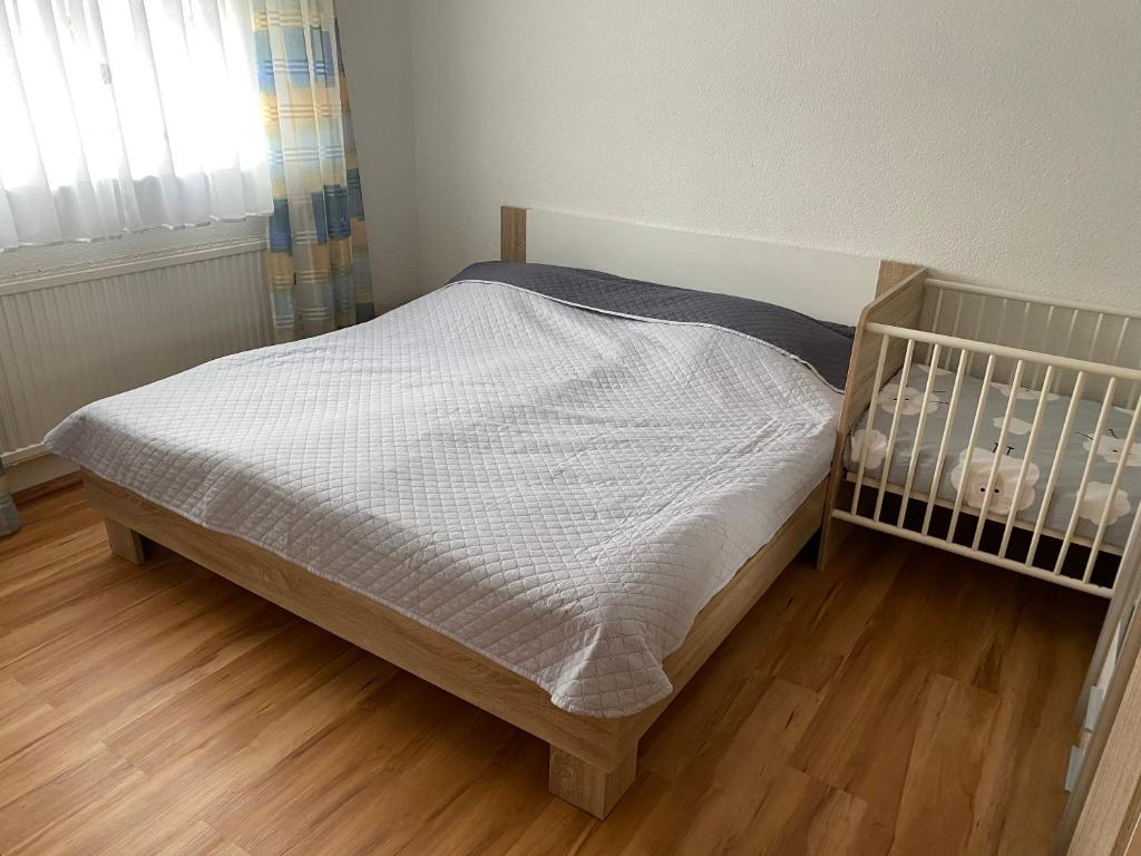 een wieg in een slaapkamer met een houten vloer bij Ferienwohnung in Emmingen-Liptingen