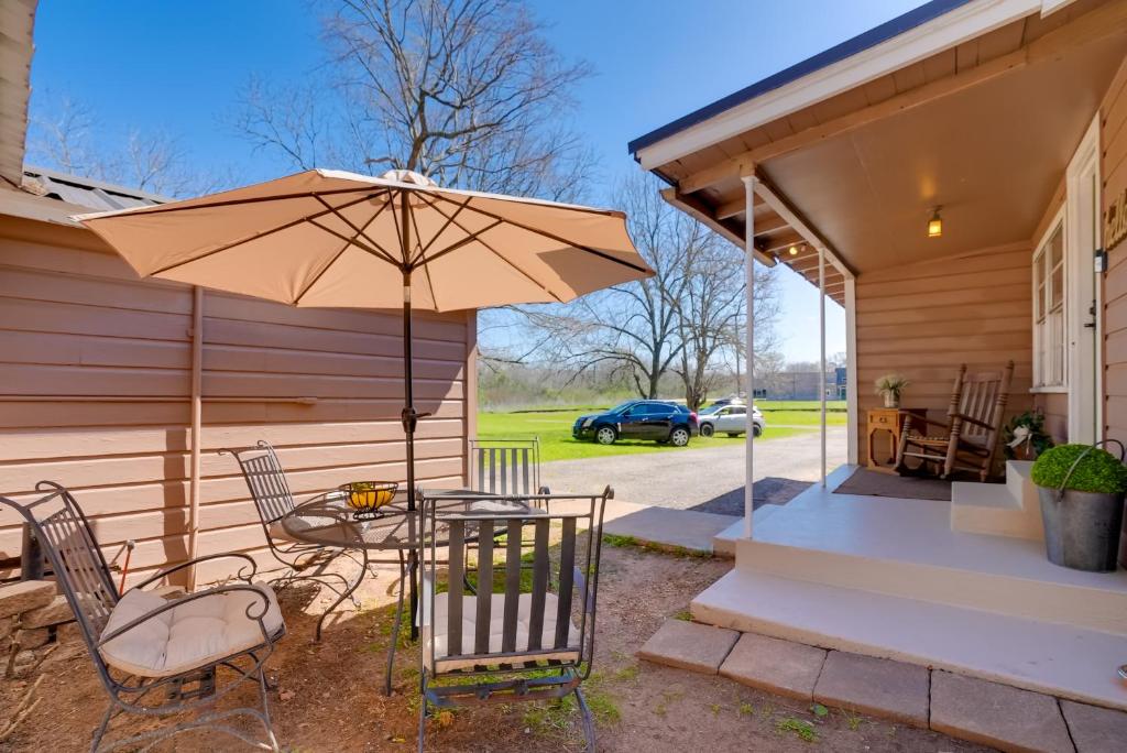 un patio con mesa y sombrilla en Rusk Retreat with Fire Pit, Grill and Countryside View, en Rusk