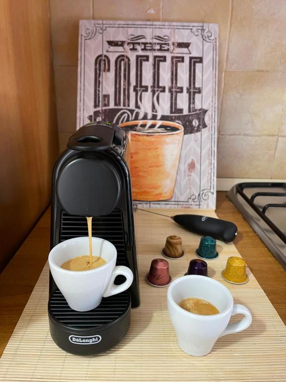 una macchinetta del caffè seduta su un bancone con due tazze di caffè di La Casa di Gió in Centro a Olbia