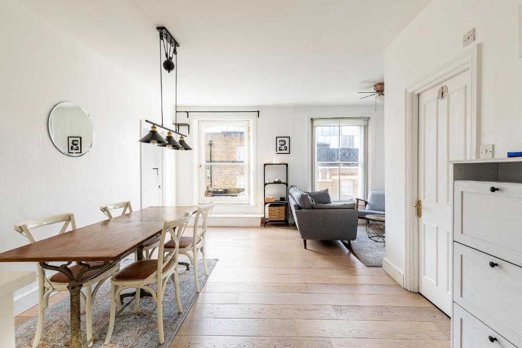 a kitchen and dining room with a table and chairs at Converted Brewery Apartment with Terrace in London