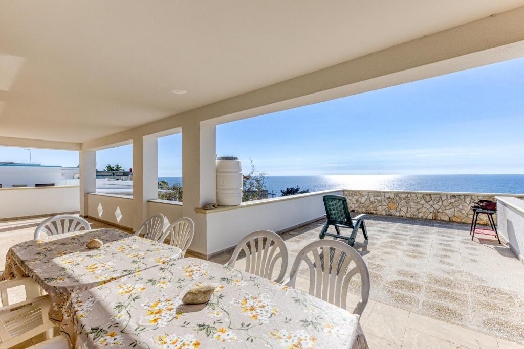 a dining room with a table and chairs and the ocean at Casa Puzzedde in Castrignano del Capo