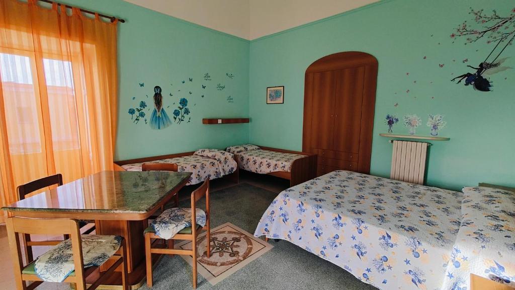 a bedroom with two beds and a table and a table and chairs at B&B Relax in Meta