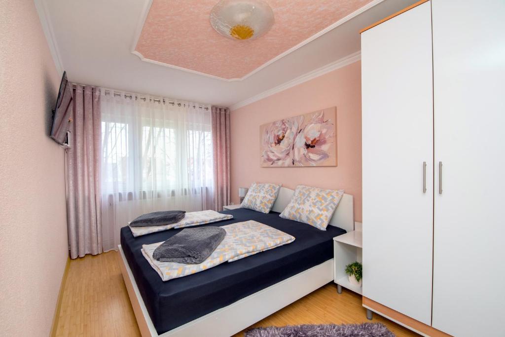 Habitación pequeña con cama y ventana en Apartman Pannonia en Osijek