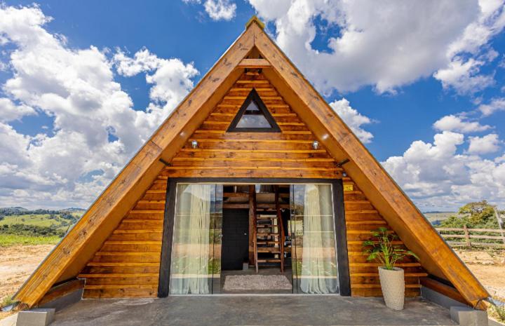 a small log house with a triangular roof at Ecovalle São Thomé - Chalé do Sol in São Thomé das Letras