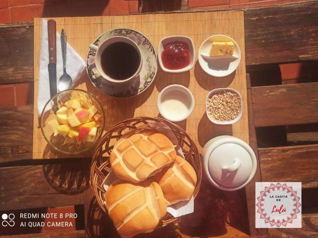 una mesa con platos de comida y una taza de café en La casita de Lulú, en Arequipa
