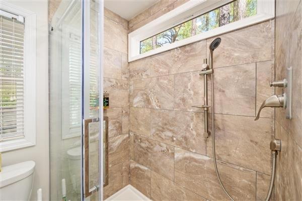uma casa de banho com um chuveiro e uma porta de vidro em Jellystone Park Birchwood Acres em Greenfield Park