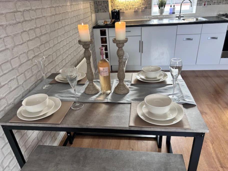 a table with plates and candles on top of it at Cathedral Walk 3 Bed Coachhouse in Lichfield