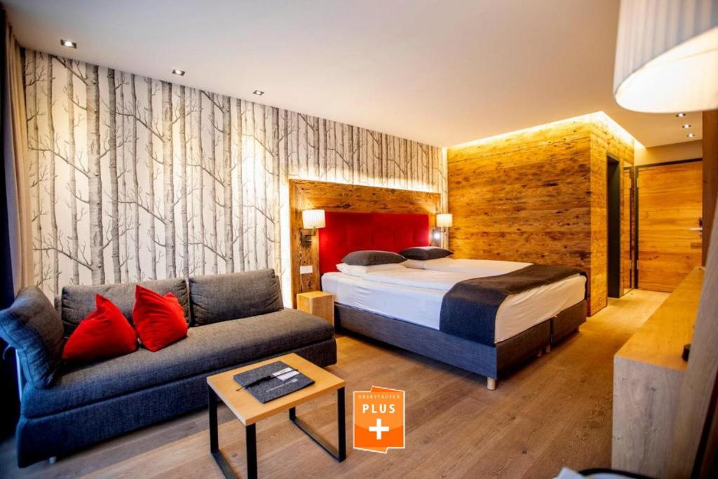ein Hotelzimmer mit einem Bett und einem Sofa in der Unterkunft Chalet Ifen am Hochgrat in Oberstaufen