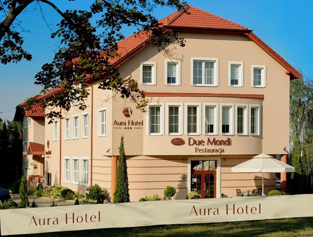 un edificio con una señal delante de él en Aura - Hotel & Restaurant & Sauna en Zielona Góra