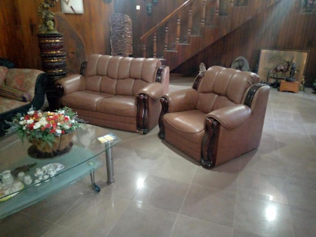2 Stühle und ein Sofa im Wohnzimmer in der Unterkunft Maliga Inn in Gampola