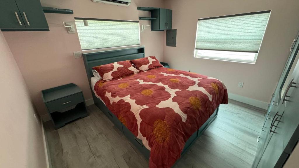 a bedroom with a bed with a floral comforter at Flamingo Tiny Home in Sarasota