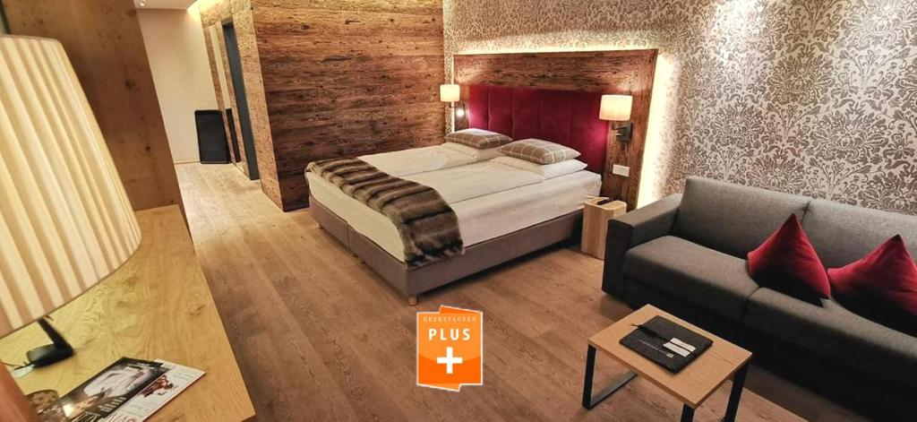 une chambre d'hôtel avec un lit et un canapé dans l'établissement Chalet Sinswang am Hochgrat, à Oberstaufen