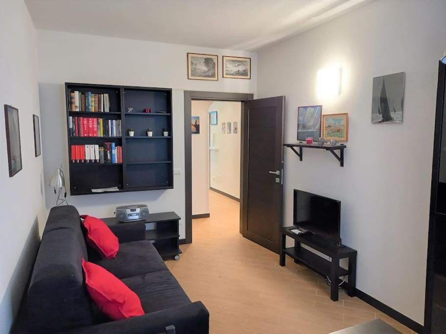 een woonkamer met een zwarte bank en een open haard bij Casa Rolecca - Nel Cuore di Rapallo in Rapallo