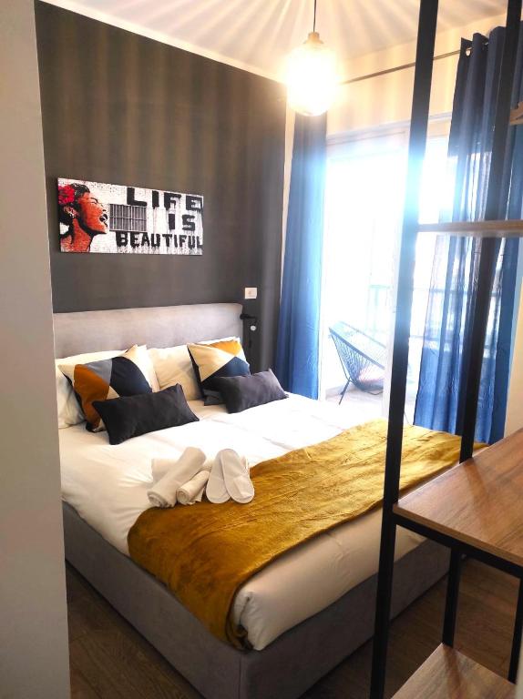 1 dormitorio con 1 cama grande con sábanas y almohadas blancas en Michelangelo Airport Suite Room en Fiumicino