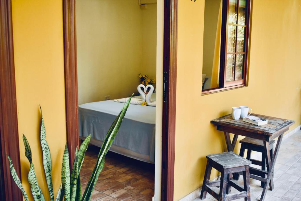 a room with a bed and a table and a mirror at Hotel Las Hamacas in Santa Catalina