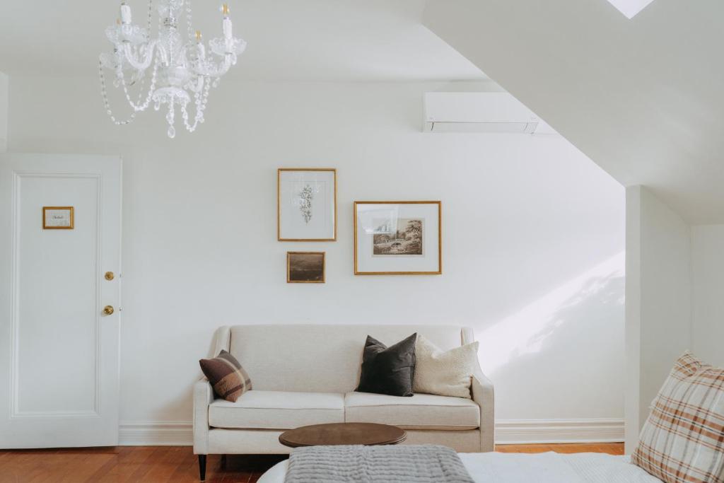 a living room with a white couch and a chandelier at No. 5 East in Winnipeg
