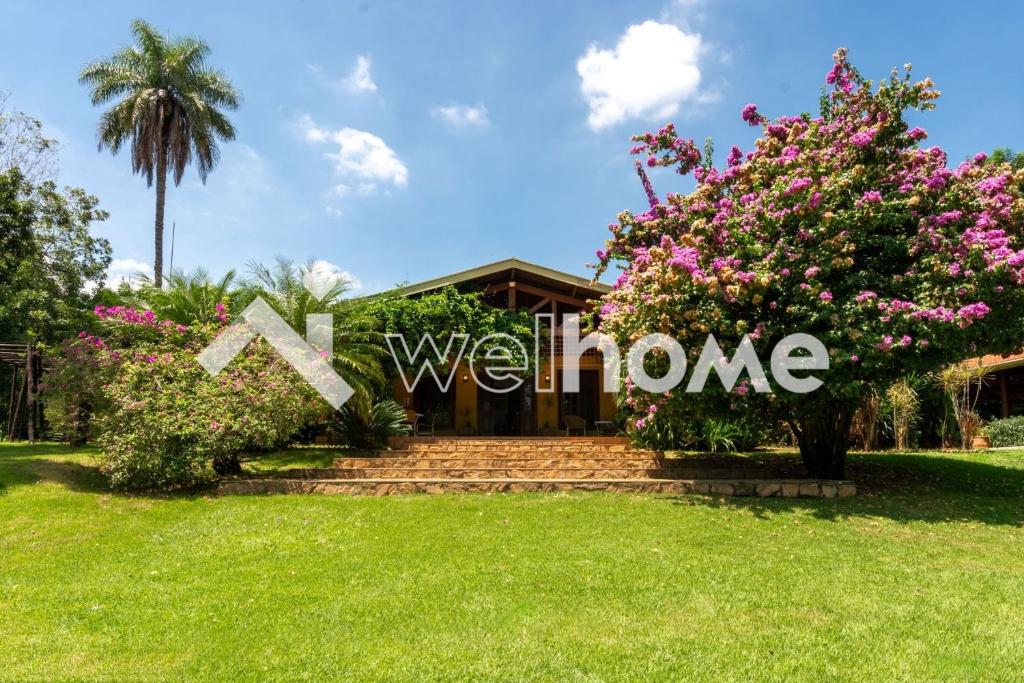 a house with a garden and a sign that says welcome at Sítio com piscina e churrasqueira em Indaiatuba in Campinas