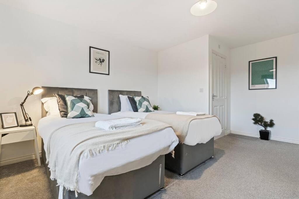 a bedroom with two beds and a night stand with a desk at Anglian Retreat - Close to City Centre - Free Parking, Fast Wifi and Smart TV by Yoko Property in Coventry