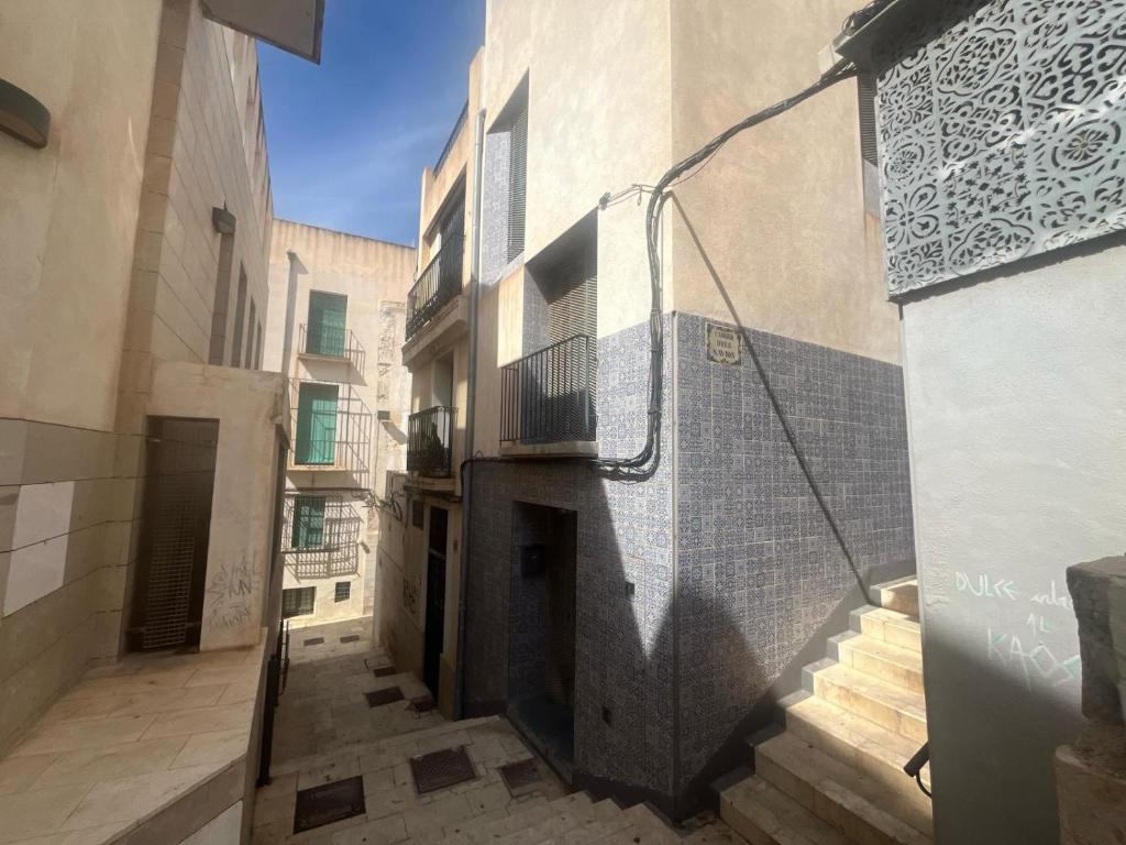 an alley in a building with a shadow on the wall at Casa Enroque in Alicante