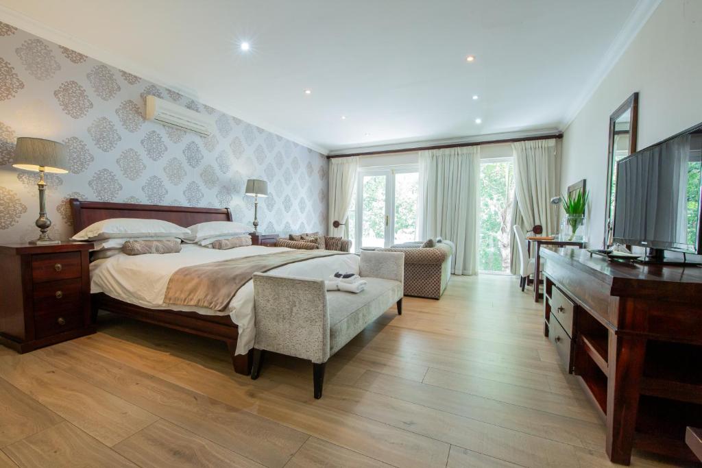 a bedroom with a large bed and a television at Belvedere Boutiqe Hotel in Windhoek