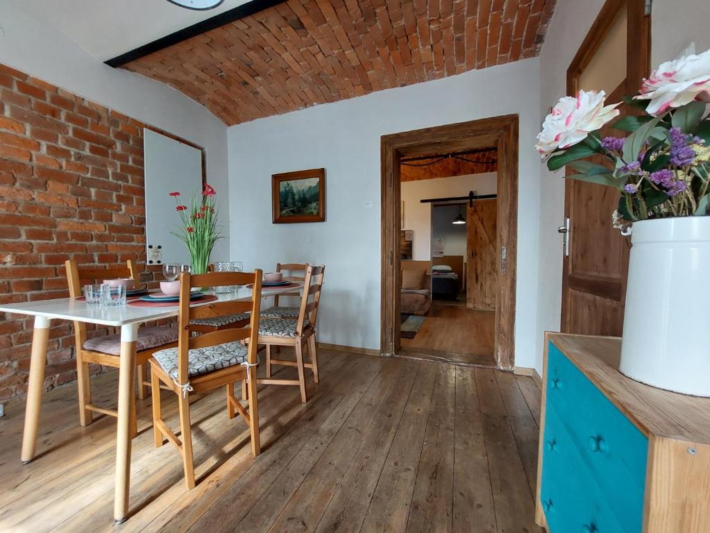 a dining room with a table and chairs and a brick wall at Apartamenty Nova na Krakowskiej No 4 in Bielsko-Biała