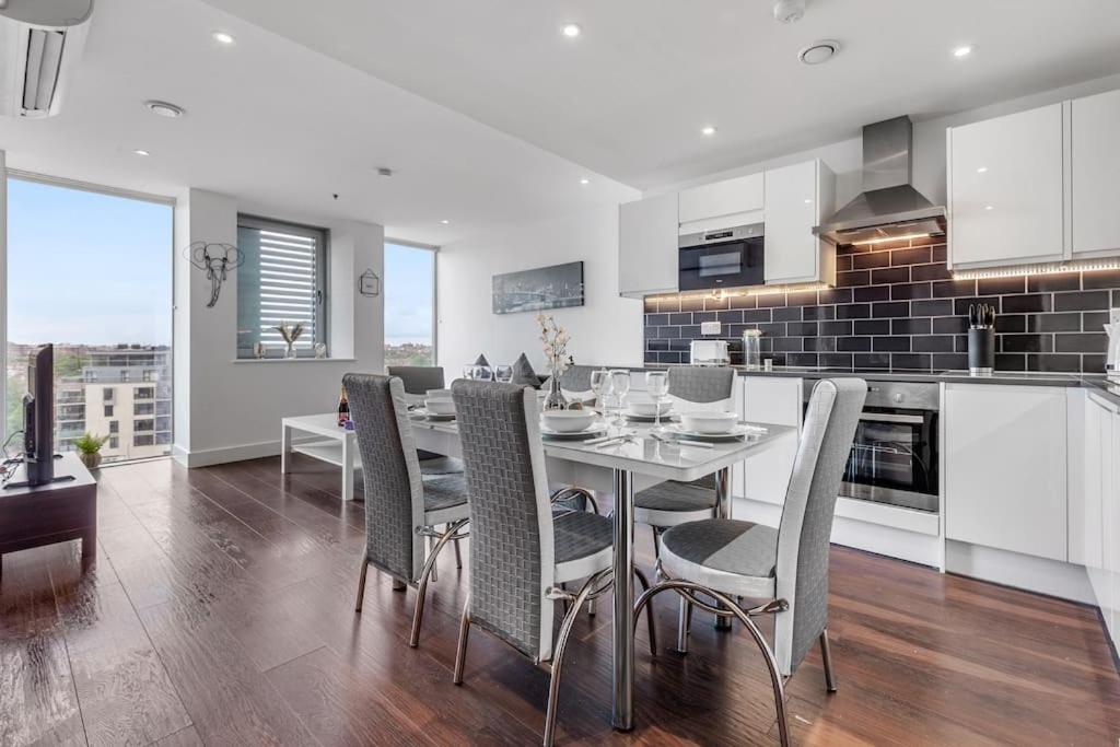 a kitchen and dining room with a table and chairs at New Apartment in Britannia point BP4 in London