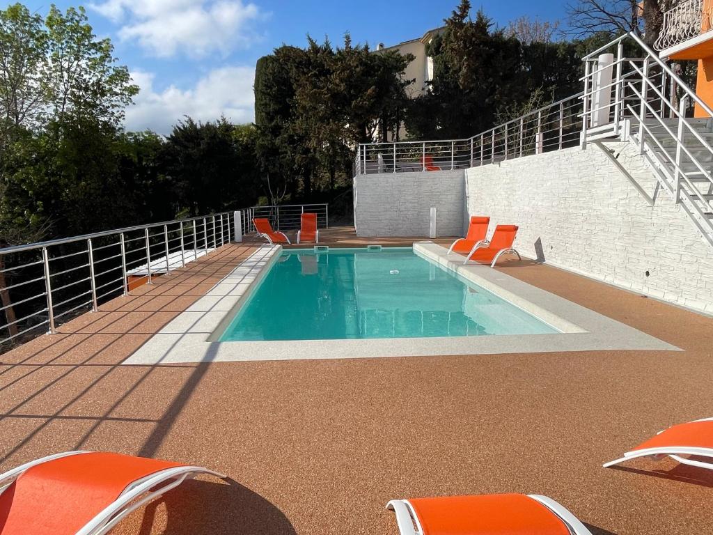 uma piscina com cadeiras laranja num pátio em Brand New Luxury Villa 6BR 11pax AC Heated Pool em Cagnes-sur-Mer
