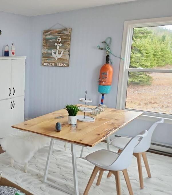 a wooden table and chairs in a room with a window at Beach Bliss, Great View in Guysborough
