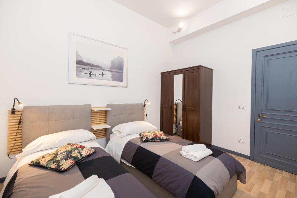 sypialnia z 2 łóżkami i drzwiami w obiekcie Adriana sweet apartment w Rzymie