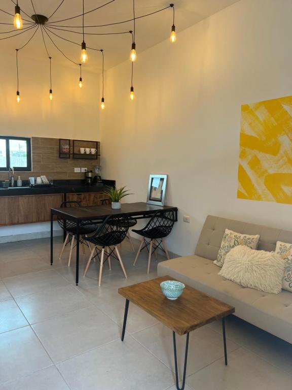 una sala de estar con un sofá y una mesa en Departamentos Plaza 32, en Mérida