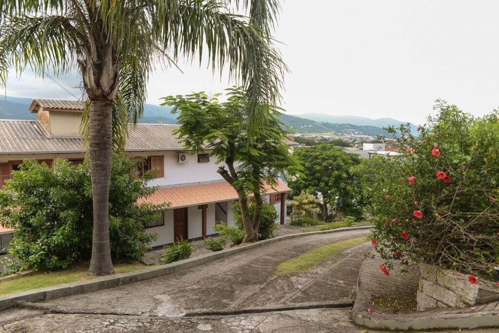 an empty road with palm trees and a building at Apto com vista para Montanha - nr 1 in Garopaba