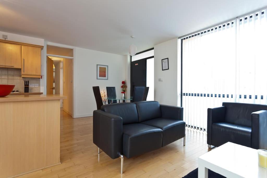 a living room with two black chairs and a kitchen at Luxury ground floor 2 Bedroom apartment Bangor. in Bangor