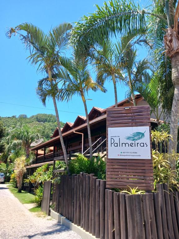 um sinal em frente a um resort com palmeiras em Pousada das Palmeiras em Garopaba