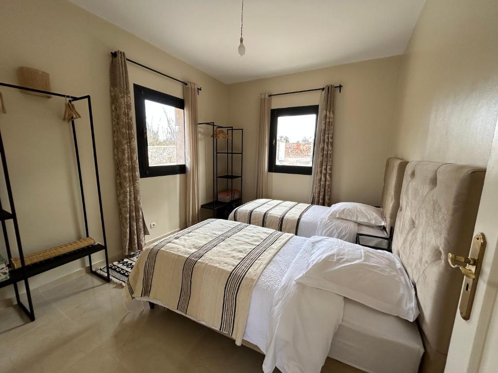 - une chambre avec 2 lits et 2 fenêtres dans l'établissement Harmonie des alizés, à Essaouira