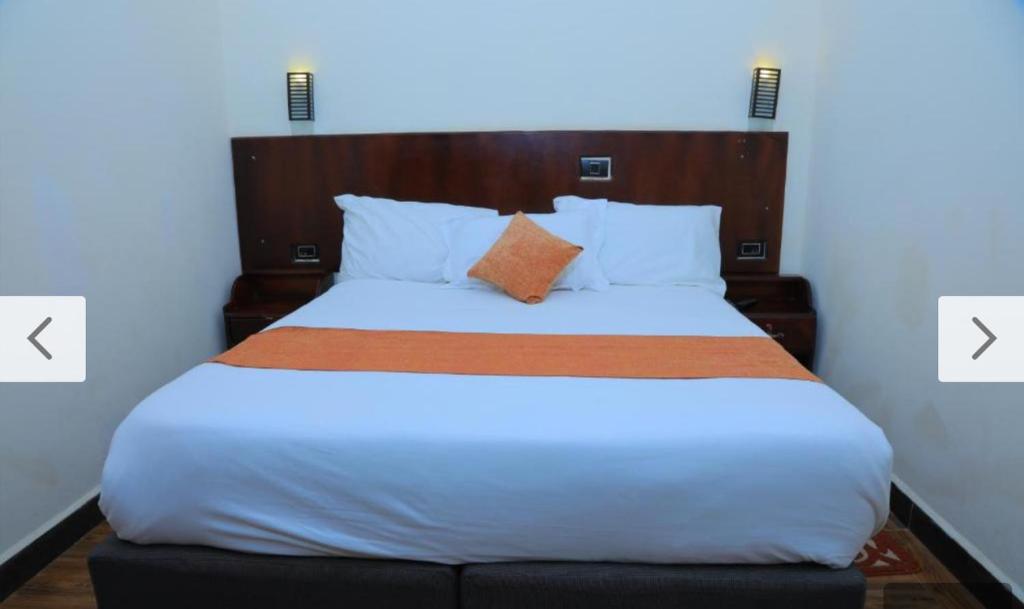 a bed in a room with two pictures of a bed at Obelisk Hotel Axum in Āksum