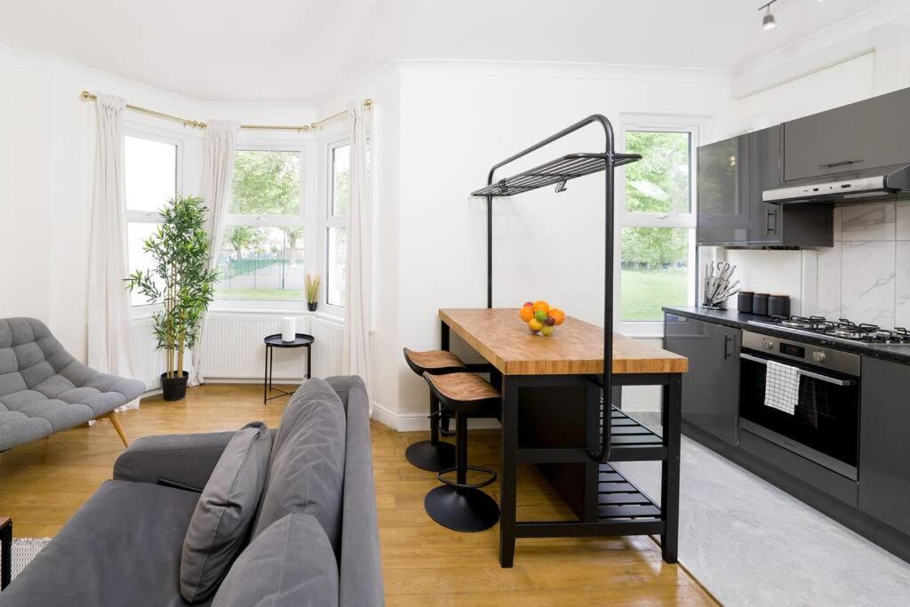 a kitchen and living room with a table and a couch at Delphina - Spacious 2BR Modern Maisonette in London