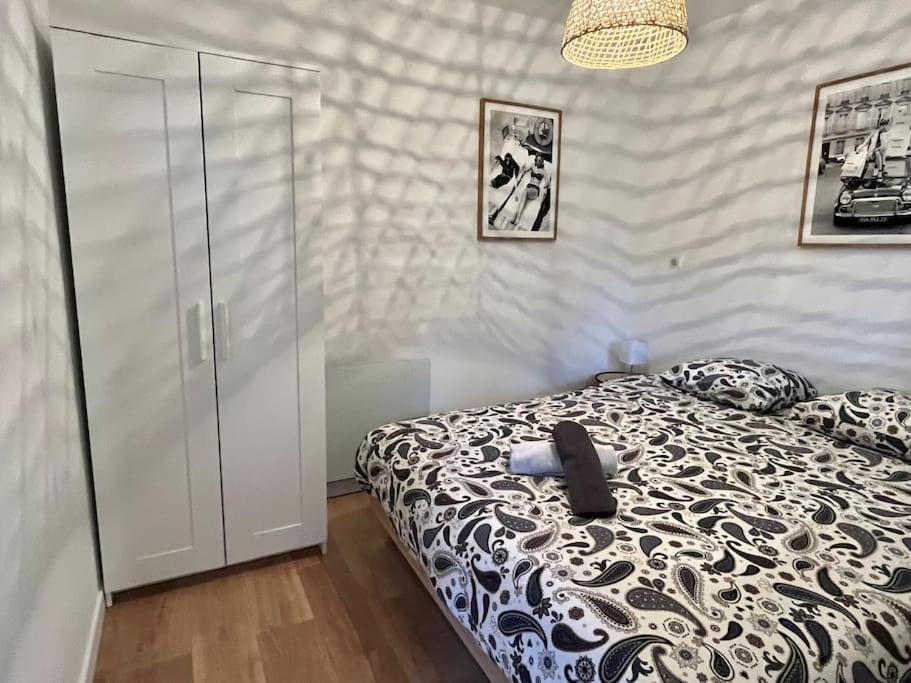 a bedroom with a bed with a black and white comforter at Appartement cosy plein centre in Douai