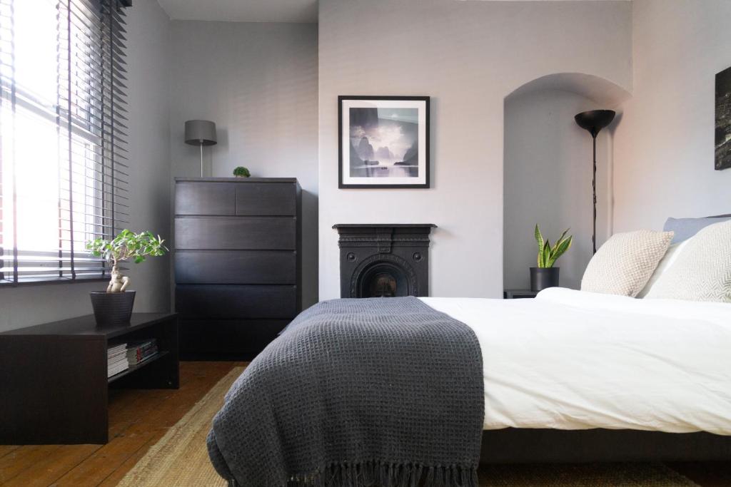 a bedroom with a bed and a fireplace at Townhouse in trendy suburb of Hoole in Chester