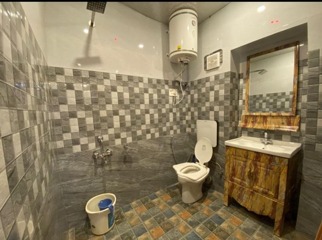 ein Badezimmer mit einem WC, einem Waschbecken und einem Spiegel in der Unterkunft Ak Residency-18 in Noida