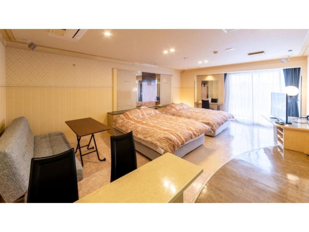 1 dormitorio con cama, mesa y escritorio en SHIZUKUISHI RESORT HOTEL - Vacation STAY 29557v, en Shizukuishi