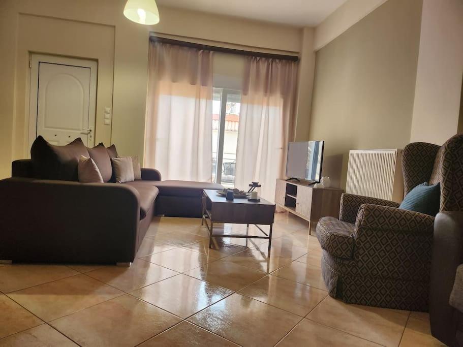 a living room with a couch and chairs and a tv at 'Elia gytheio in Mavrovouni