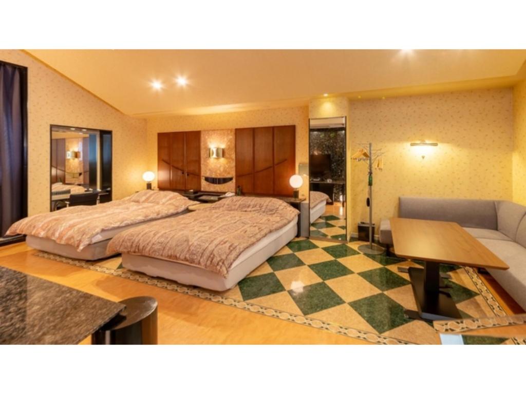 um quarto de hotel com uma cama grande e um sofá em SHIZUKUISHI RESORT HOTEL - Vacation STAY 29563v em Shizukuishi