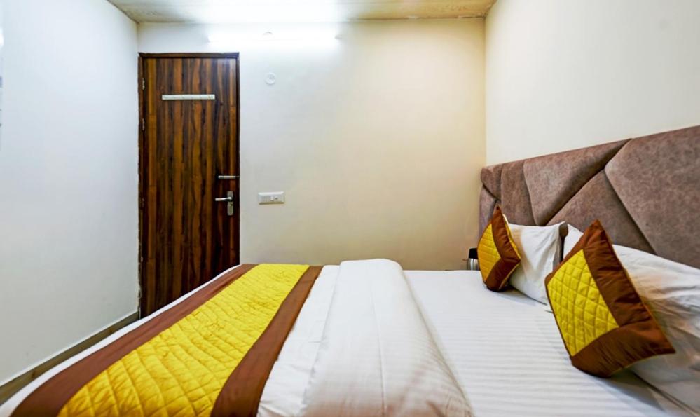 a bedroom with a bed with a yellow blanket on it at Hotel Preet - Family Hotel in New Delhi